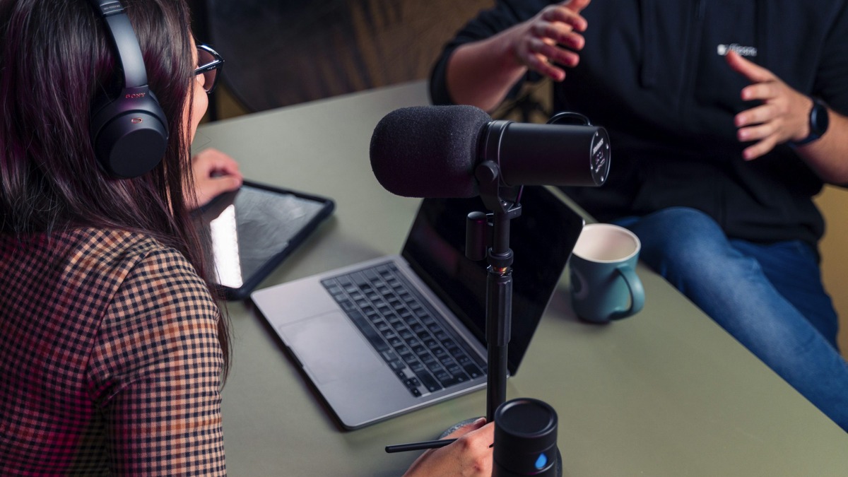 A person wearing headphones working on music with a laptop