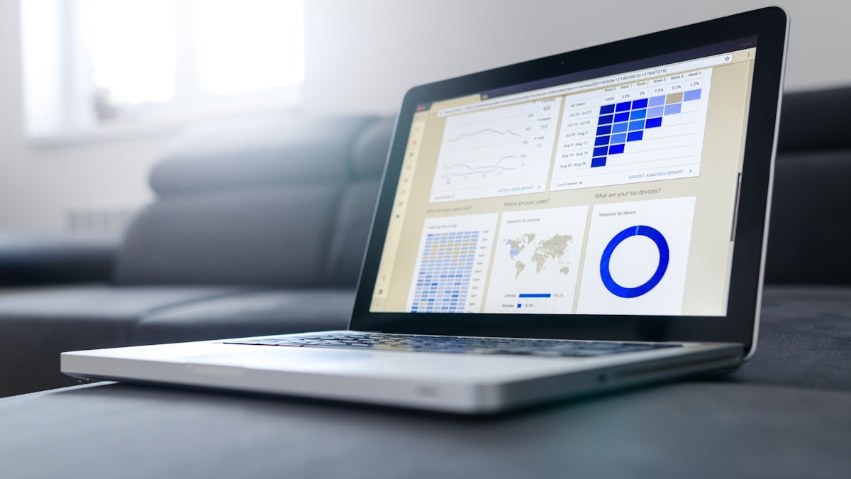 Laptop displaying a multi-panel data analytics dashboard with charts and performance metrics