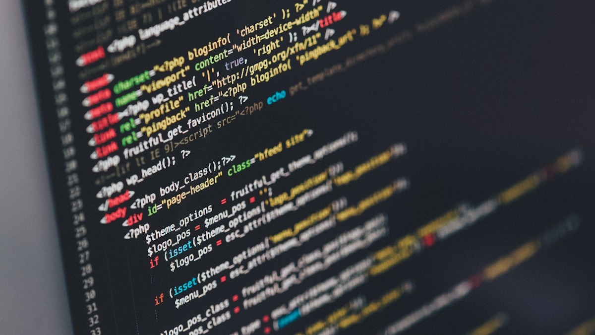 A developer working at a monitor with code visible on screen