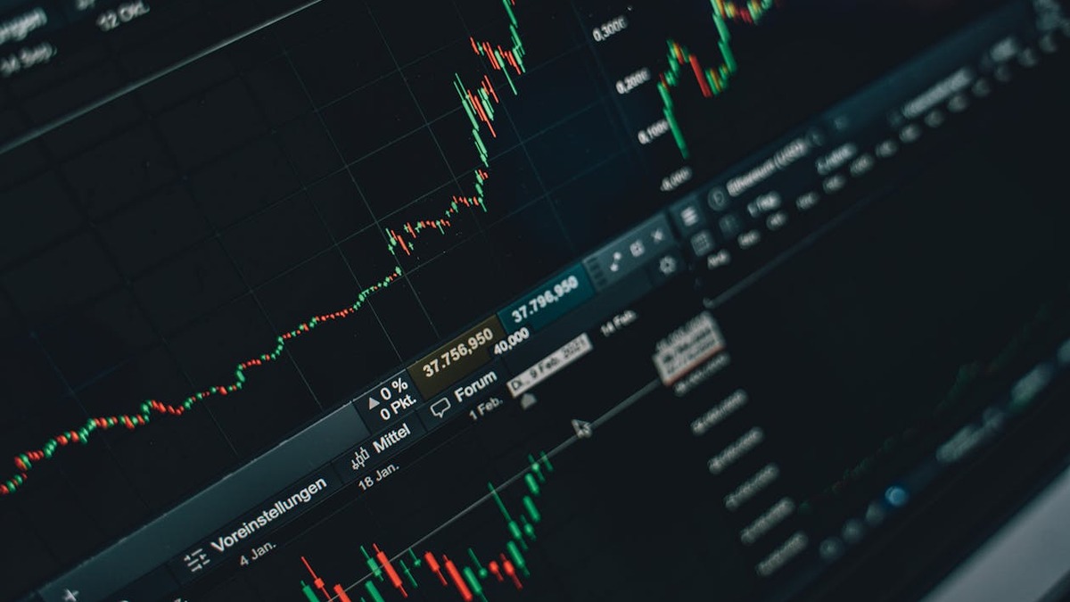 Multiple financial graphs displayed on a laptop screen
