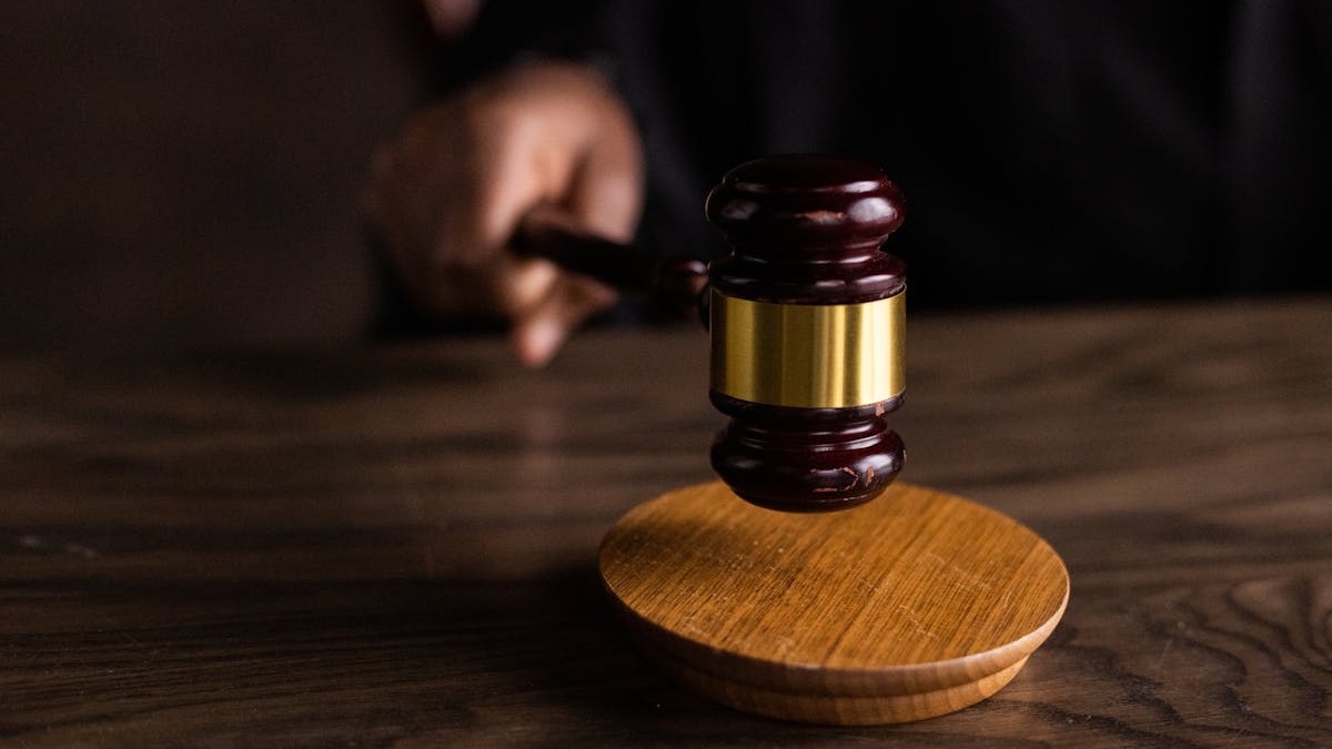 A wooden gavel on a judge's bench symbolizing the upcoming April trial